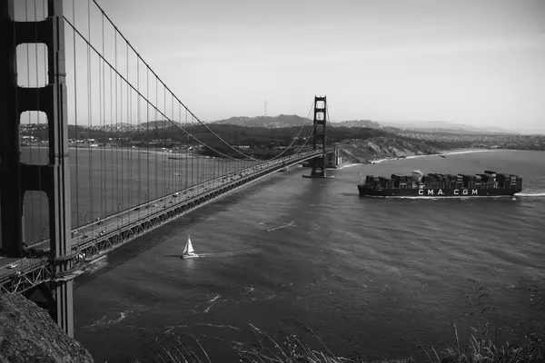 container ship crossing a bridge