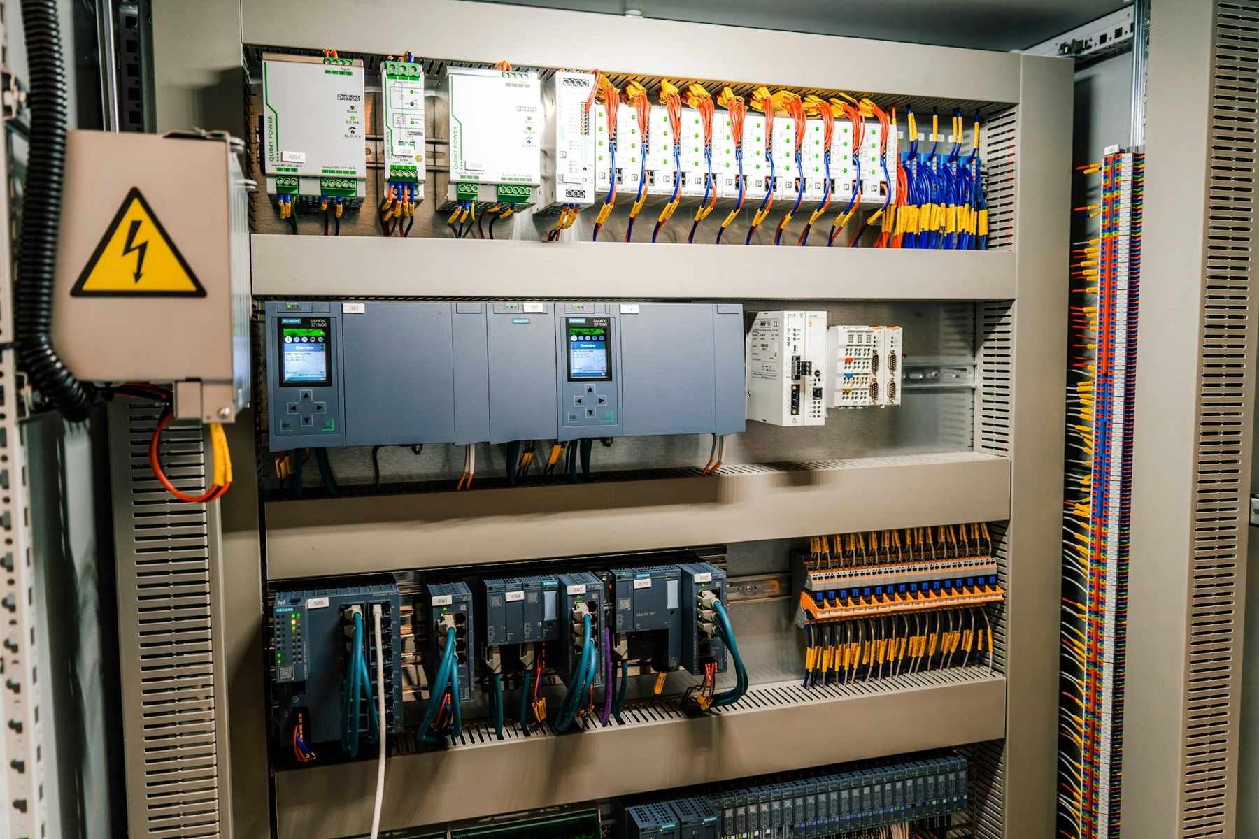 Industrial control cabinet with electronic modules and organised wiring