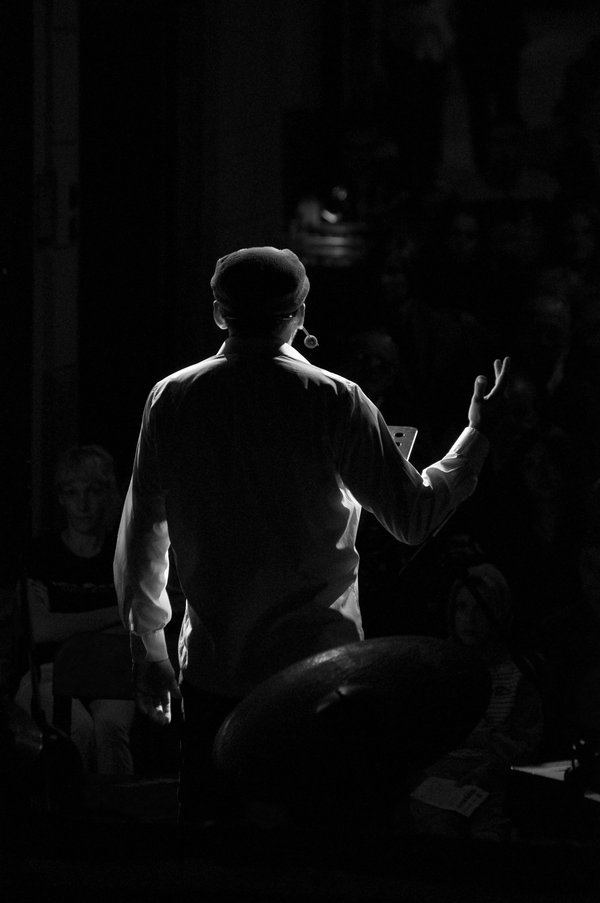 speaker speaks to the audience with his back to them