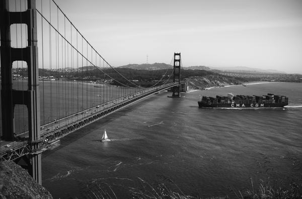 vaixell amb contenidors creuant un pont