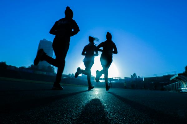 silhouette of runners at dawn