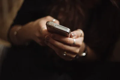 Mujer sujetando y usando un teléfono móvil