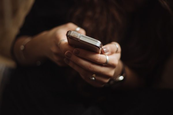 Mujer sujetando y usando un teléfono móvil